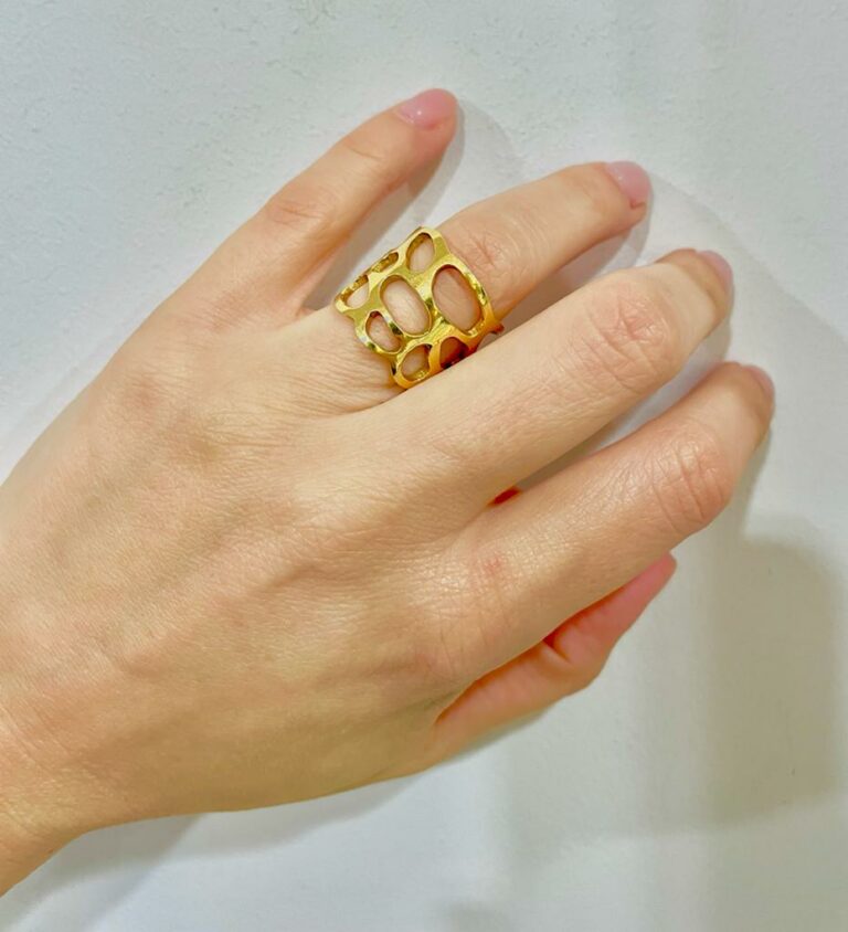 Φαρδύ εντυπωσιακό cuff-δαχτυλίδι από κίτρινο χρυσό Κ18 με διάτρητο σχέδιο και λουστρέ φινίρισμα.